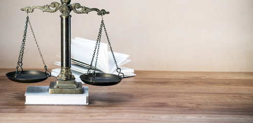 Law scales on wooden desk concept for justice and equality