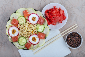 Raw fish, rice and hefty vegetables on a wooden background. Healthy eating concept