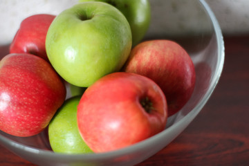 apples in a transparent bowl  on a wooden table