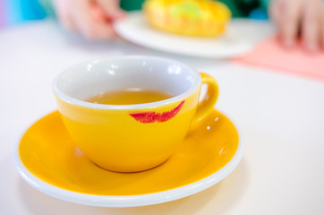 Red lipstick track on the yellow cup