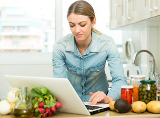 Young woman cooking recipe from the Internet