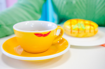 Red lipstick track on the yellow cup