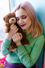 Close up portrait of hipster girl. Pretty girl hugs toy bear