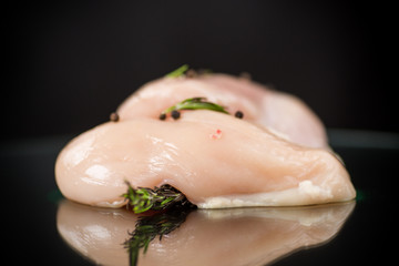 Chicken fillet with spices and rosemary on a dark