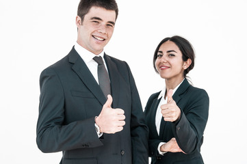 Happy confident professionals expressing approval. Young man and woman in formal suits smiling at camera and showing thumbs up. Positive feedback concept