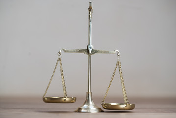 Law scales on wooden desk concept for justice and equality