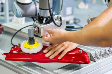 The engineer setup and teaching  the automatic polishing robotic system in the automotive assembly line . The hi-technology in automotive parts manufacturing process by robotic system.