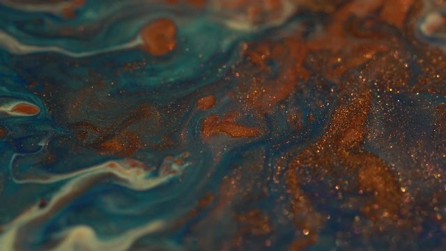 Copper, bronze, ochre, yellow, blue colors glittering Ink. Colorful Liquids in Motion