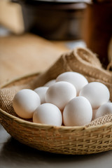 Chicken eggs in basket on table.