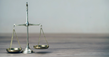 Law scales on wooden desk concept for justice and equality