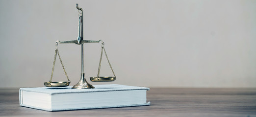 Law scales on wooden desk concept for justice and equality