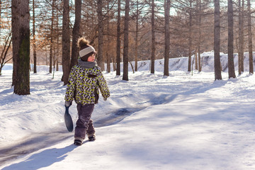 Little boy walks in the snow