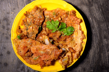 omelet is decorated in yellow plate with green coriander leaves