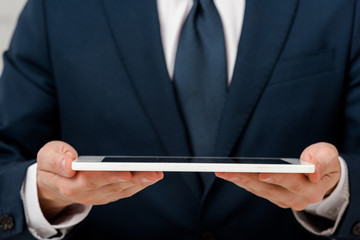 cropped view of businessman holding digital tablet