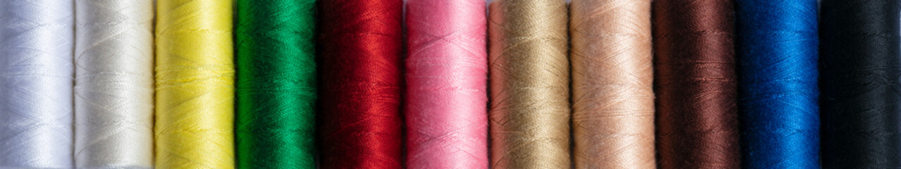 Colorful sewing threads in a row for a banner. The texture of multi-colored threads.