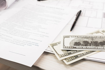 selective focus of dollar banknotes near documents and pen on desk