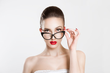 Portrait of beautiful skeptical woman in stylish cat eye eyeglasses, thinking and looking at you...