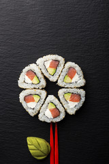 Sushi Rolls with tuna on a dark background. Japanese traditional roll with tuna. Sushi set on a stone plate and dark concrete background. Sushi roll set and chopsticks. Fresh Japanese cuisine. asian f
