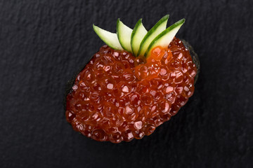 Gunkans with caviar on a dark background. Close up view on gunkan sushi with caviar on dark stone background. Fresh Japanese cuisine. asian food. Sushi image for menu. sushi with red caviar. 