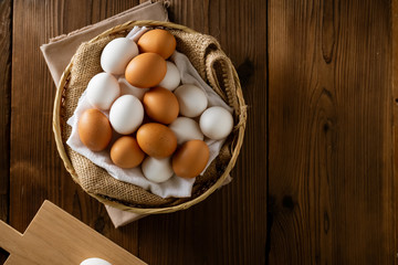 Chicken eggs in basket on table.