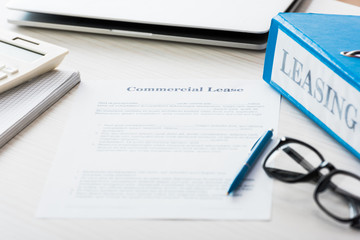selective focus of folder near document with commercial lease lettering on desk
