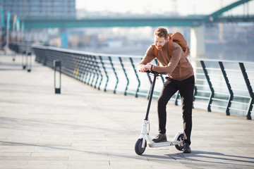 Young businessman on e scooter in the city