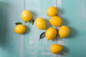Fresh lemons, citrus fruits on blue wooden background