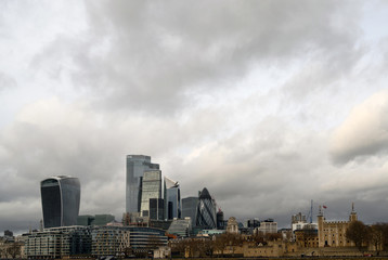 Fototapeta na wymiar City of London in the UK. View over the River Thames to the city of London and the Tower of London with dramatic stormy clouds. Cityscape of the business district and Tower of London in 2020.