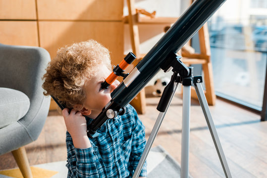 Smart Child Looking Through Telescope At Home