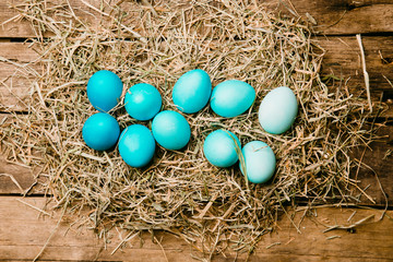 Fototapeta na wymiar Ten easter eggs in blue gradient color design. On a wooden vintage background..