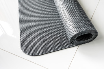 gray yoga mat rolled up on the floor, sport, healthy lifestyle