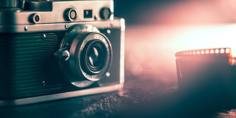 Photo camera on dark background. Close up of old retro things shooted with vintage style colors and...