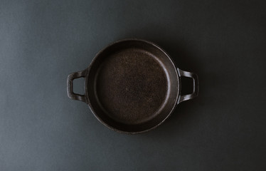 Empty black metal plate on a black background. Top View