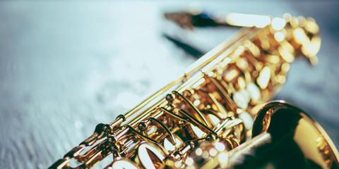 Golden colored saxophone. Close up of old retro things shooted with vintage style colors and toned....