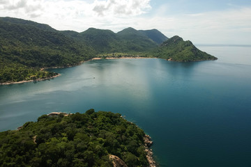 aerial shot with drone of green mountains and blue water