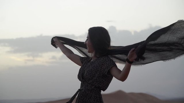 woman dancing with a scarf in the desert