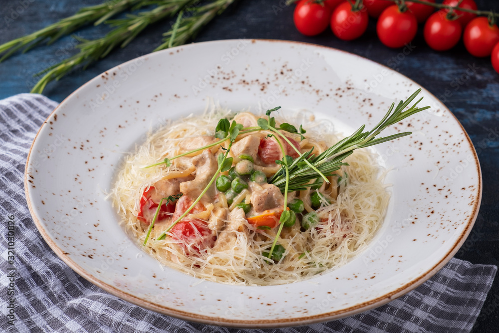 Wall mural delicious spaghetti with chicken, vegetables and cheese on a plate.