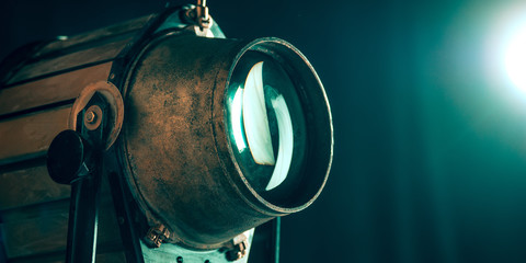 Projector lens on dark background. Close up of old retro things shoot with vintage style colors and toned. Flyer for your ad. Concept of retro style, history return, fashioned things, hobby, memories.