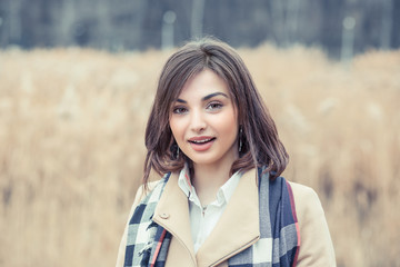 Woman smiling with perfect smile and white teeth in a park and looking at camera telling something