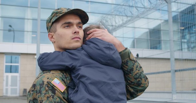 Soldier holding son in his arms.