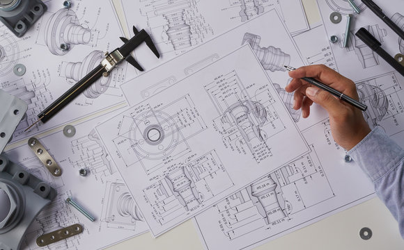 Engineer technician designing drawings mechanical parts engineering Engine.manufacturing factory Industry Industrial work project blueprints measuring bearings caliper tools