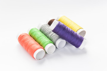 colorful spools of thread close-up on a white background