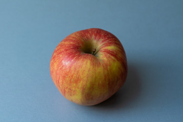 Close-up of isolated red and yellow delicious juicy apple on modern kitchen countertop