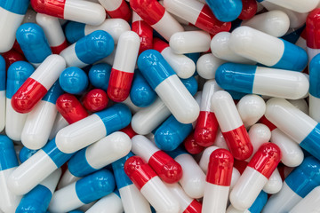 Drugs pills capsules on red blue abstract top view medicine health concept
