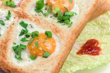 Fried scrambled quail eggs in bread toast with fresh vegetables. Creative breakfast on Valentine's or Mother's Day recipe, closeup, selective focus