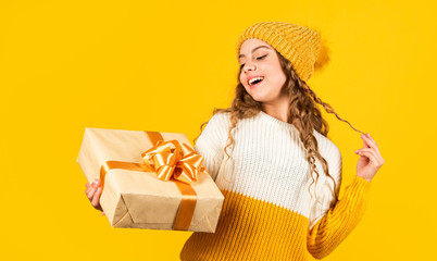 Obraz na płótnie Canvas Shopping Center. Happy little smiling girl with christmas gift box. kid hold present box yellow background. Happy Christmas and New Year. Christmas gift in hand. Christmas concept