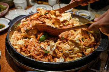 Wooden flipper stir-fried a Dakgalbi barbeque chicken on pan