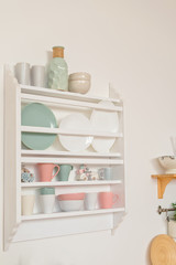 Kitchen shelves with dishes, plate and cup.