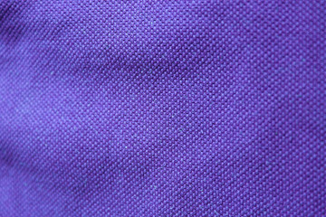 Fabric texture of vivid blue material background. Worn rough shirt, blue cotton material, textured cotton cloth. High quality clothing detail, plain colorful jacket close up view 