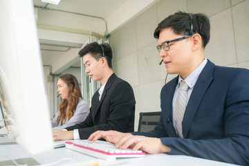 Business call center men and women team service 24 hour working on computer